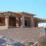 A building under construction with brick walls and wooden beams.